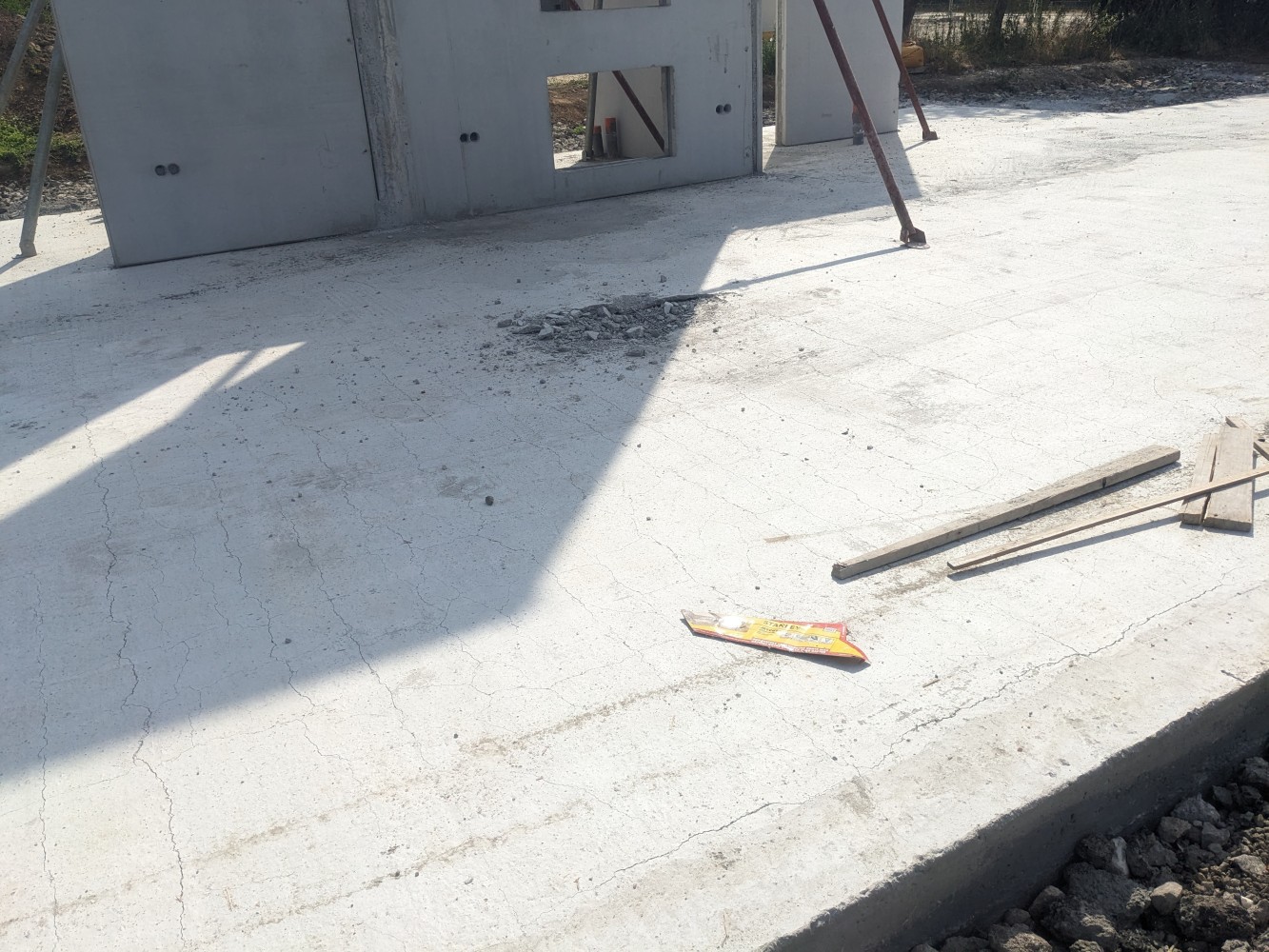 Dalle béton percée et affaissée après la chute de la machine.