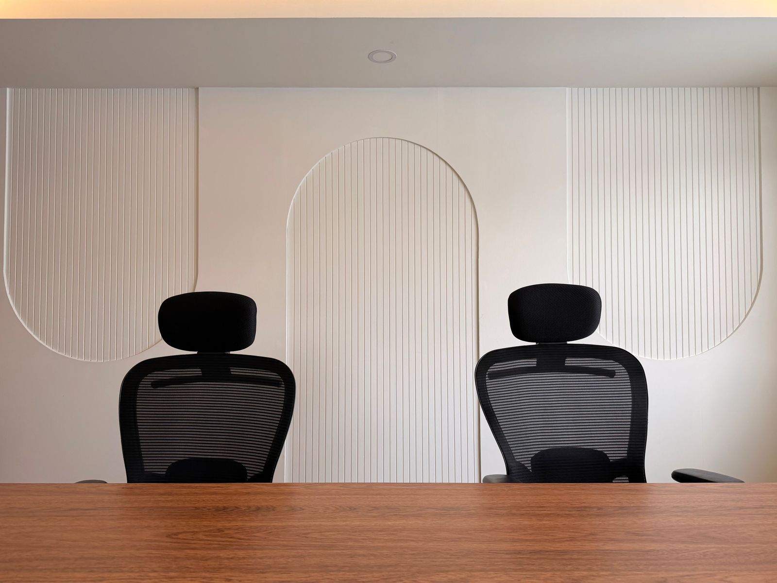Deux fauteuils de bureau se faisant face dans une pièce épurée.