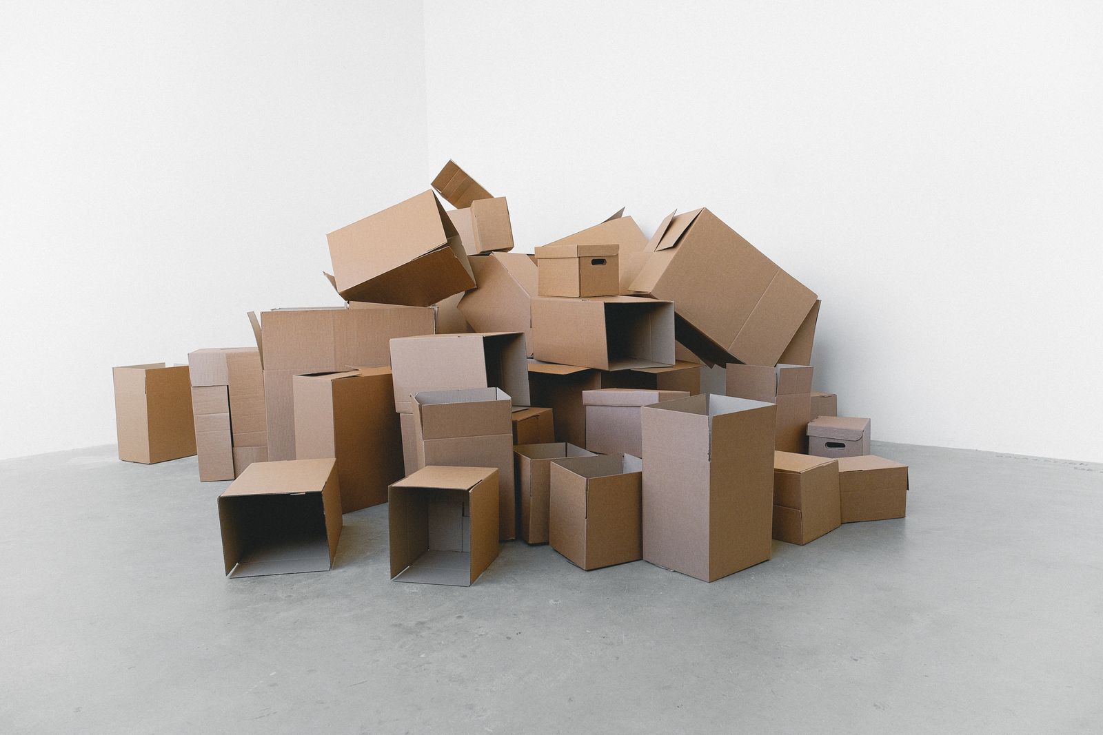 Cartons de déménagement empilés sur le sol d'une pièce vide.