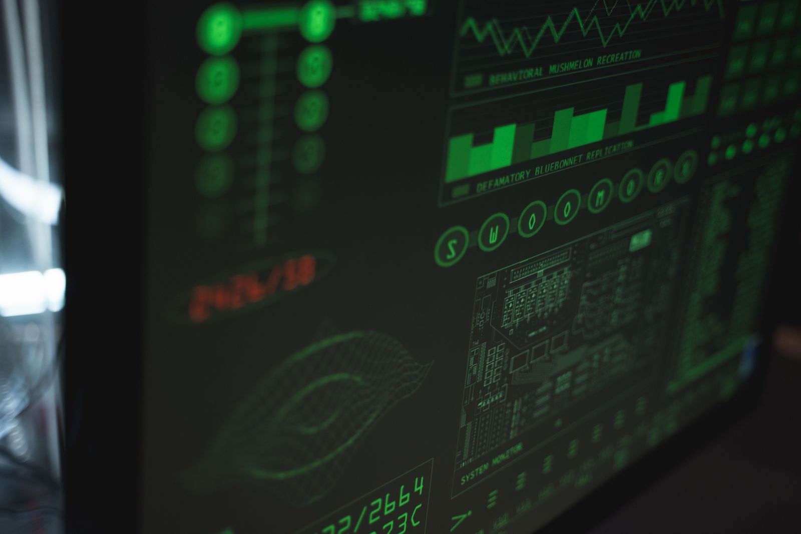 Écran d'ordinateur dans la pénombre, affichant en vert des interfaces de supervision de sécurité et des lignes de données.